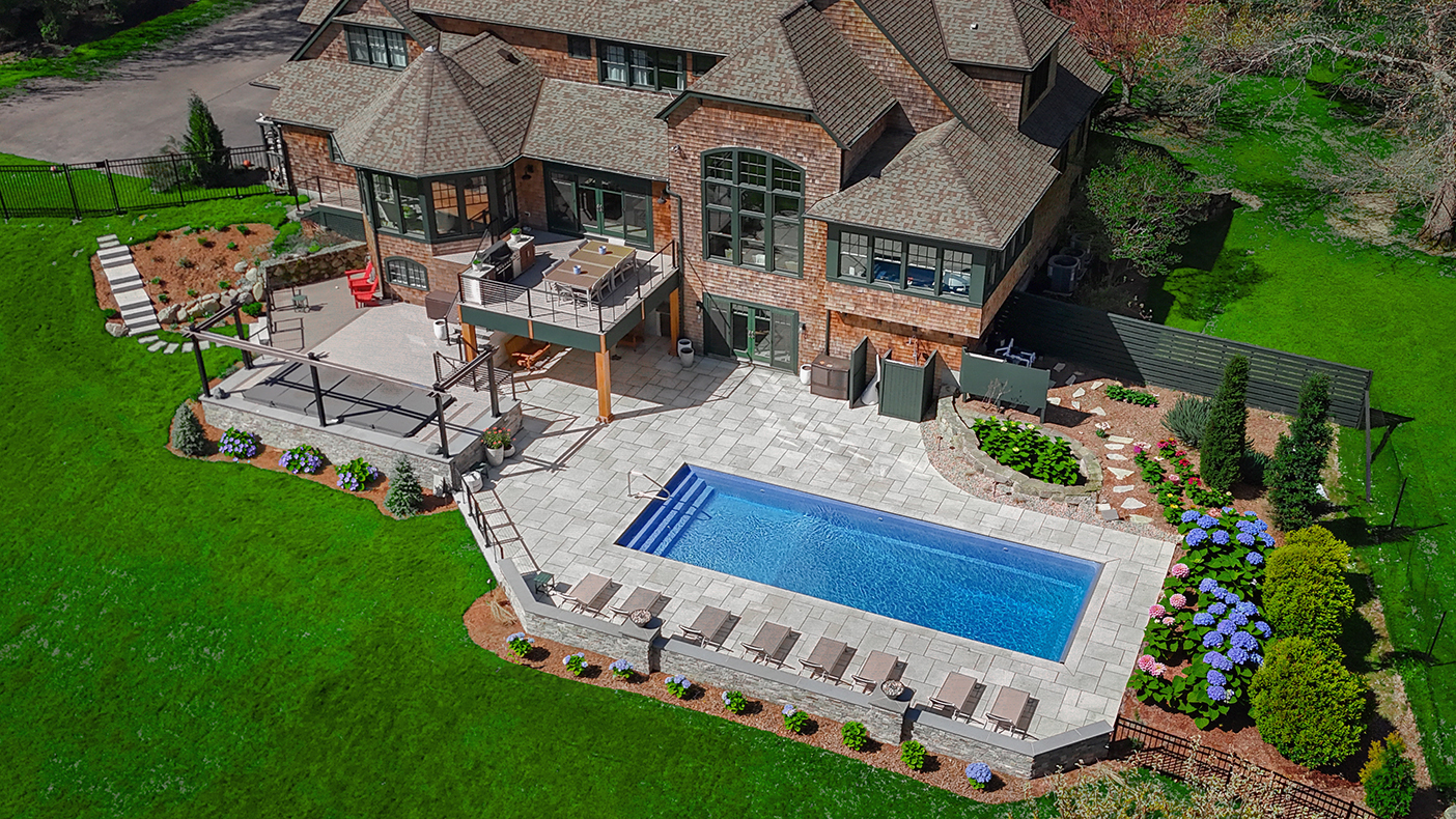 Aerial view of a luxury stone pool deck and patio installation on the South Shore